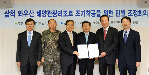 국민권익위원회 박재영 부위원장(왼쪽 세번째)이 7일 오후 서울 서대문구 미근동 소재 권익위 청사에서 2018년 평창동계올림픽 숙박시설로 사용 예정인 삼척 와우산 해양관광리조트의 착공이 부지내 군부대 휴양소 이전문제로 지연이 되면서 발생한 민원을 중재해 군 휴양소를 이전하고 2017년 1월 프레올림픽 개최전까지 리조트를 완공하기로 합의시킨 후 삼척시 행정부시장(오른쪽 세번째) 등 관계자들과 기념촬영을 하고있다.